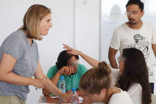 Teilnehmer:innen der Sommerschule «Projects for Marrakech – Learning from each other» sitzen gemeinsam an einem Tisch, diskutieren konzentriert und entwickeln in Gruppenarbeit ihre Designprojekte in Marrakech, 2015.