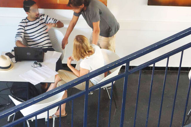 Drei Teilnehmer:innen der Sommerschule «Projects for Marrakech – Learning from each other» arbeiten in einer kleinen Gruppe am Laptop und diskutieren ihre Designideen in einem Seminarraum in Marrakech, 2015.