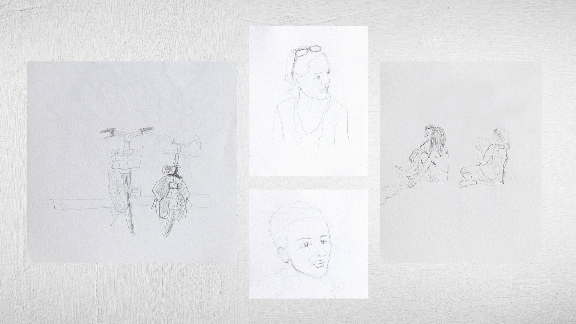 Bleistiftskizzen von Fahrrad, sitzenden Personen und Porträts auf weisser Wand, Zeichnungen von Heidrun Föhn aus dem Jahr 2010.